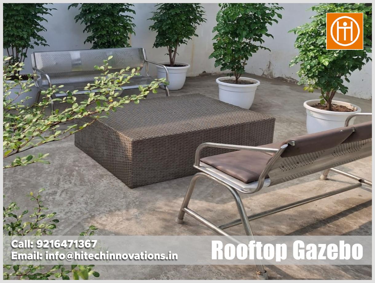 Durable stainless steel and brown cushioned outdoor seating bench paired with a rattan coffee table manufactured by Hitech Innovations.