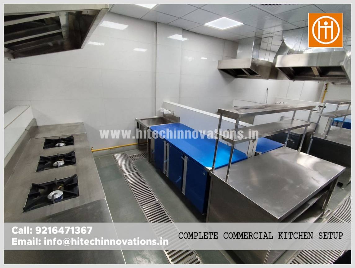 Professional kitchen installation for an IT firm in Haryana showing a multi-burner gas range, drainage systems, and heavy-duty ventilation hoods.