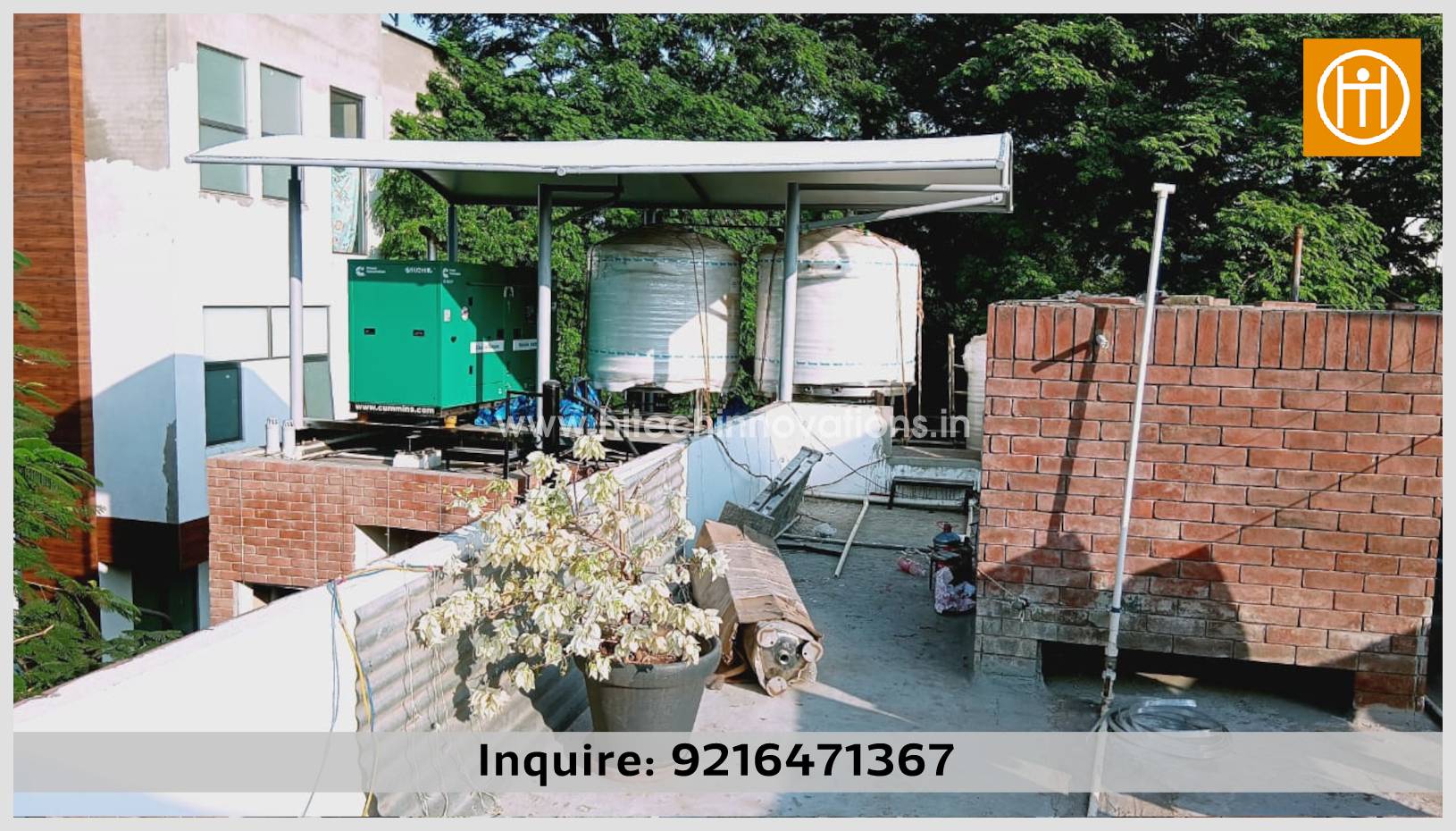 Wide rooftop view of a durable tensile membrane shade designed by Hitech Innovations, shielding critical utility equipment including an industrial generator and storage tanks from direct sunlight and rain.