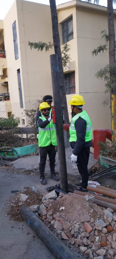 Technical team from Hitech Innovations using a spirit level to ensure perfect vertical alignment of a car shed pillar during on-site installation.