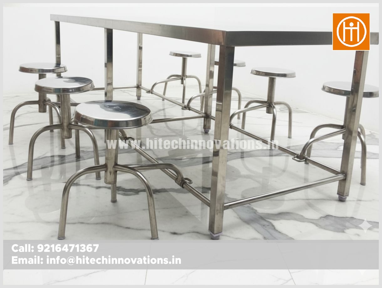 Heavy-duty 6-seater canteen dining set with high-grade stainless steel tabletop and attached swing-out stools, exclusively manufactured by Hitech Innovations for mess halls and cafeterias.