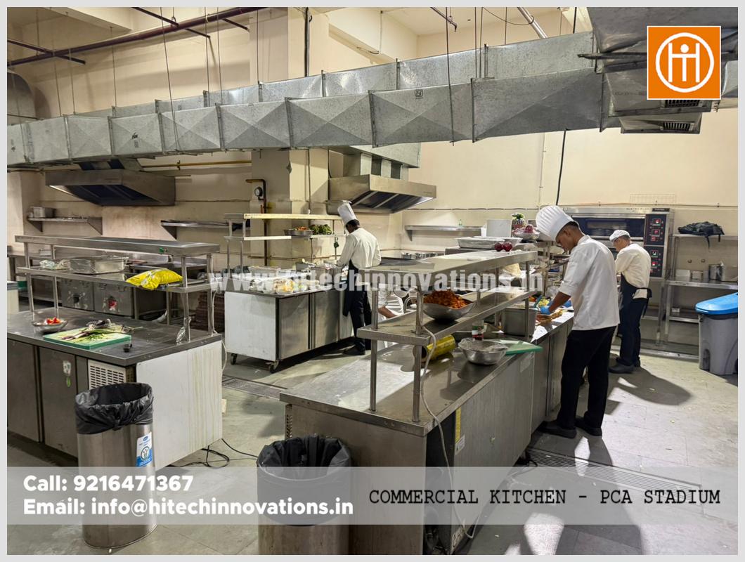 Hitech Innovations commercial kitchen setup at PCA Stadium showing a line of prep tables, commercial ovens, and specialized air filtration ducting.
