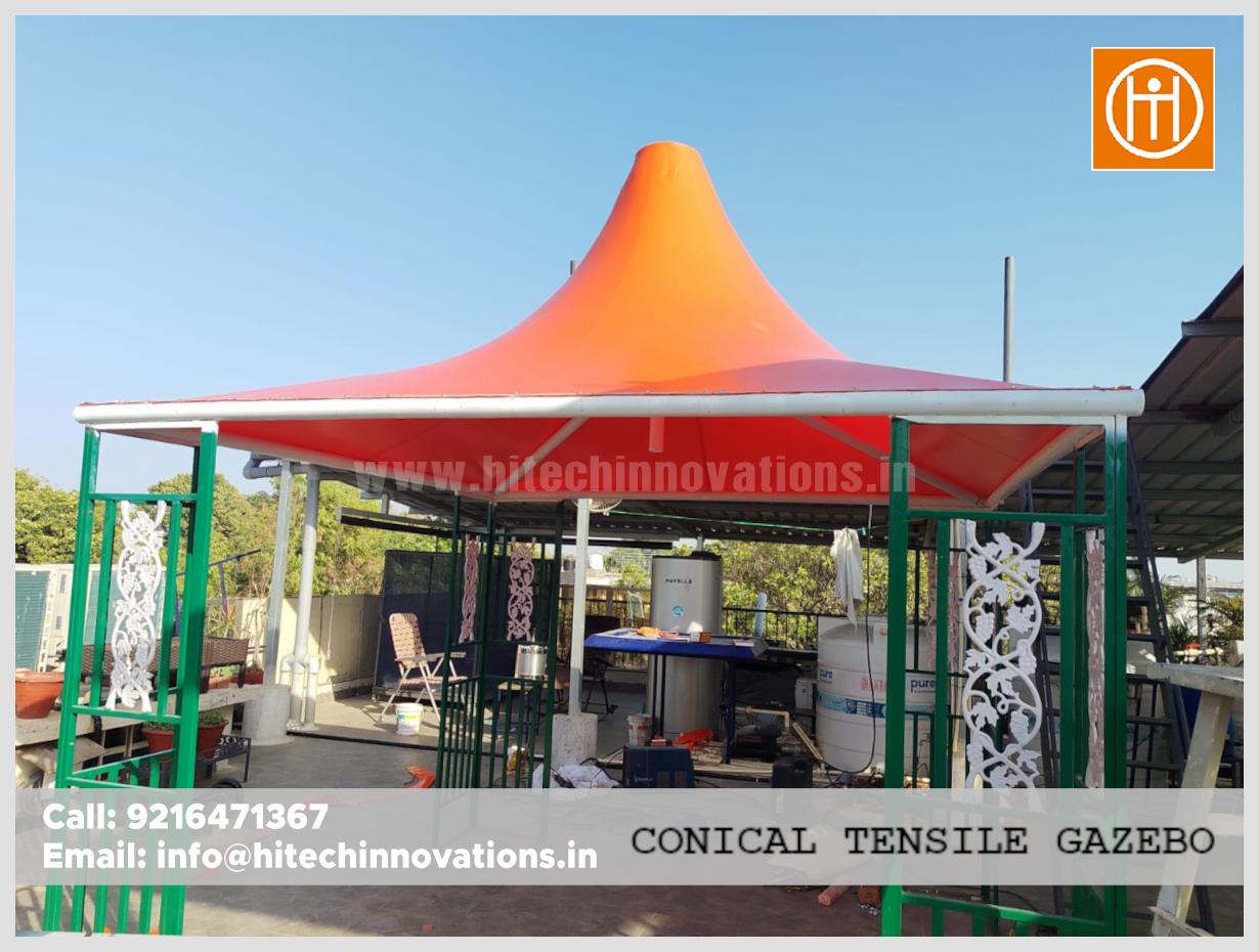 Wide angle shot of a rooftop outdoor sitting gazebo featuring a bright orange conical roof and decorative white metal work.