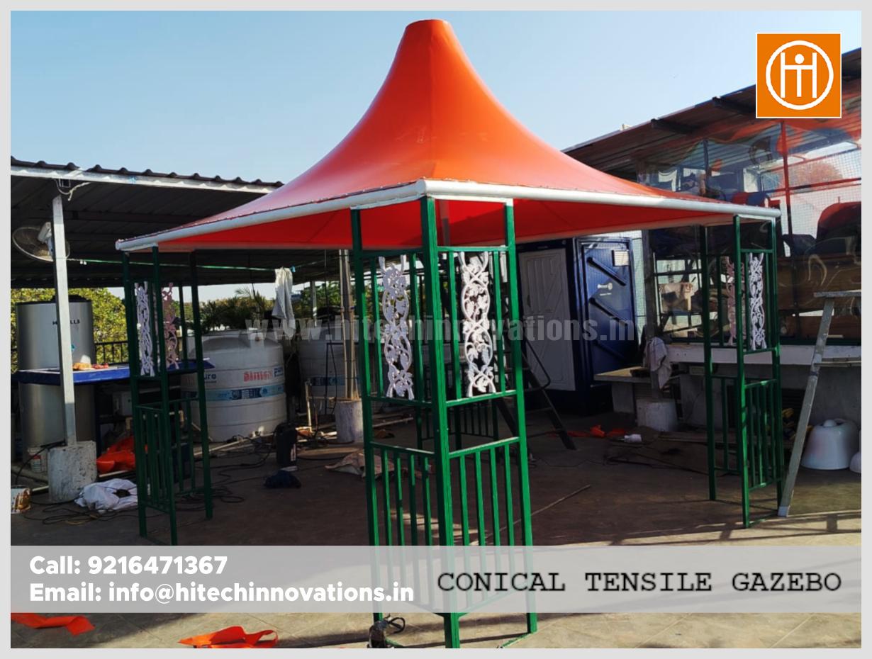 Side profile of a conical tensile gazebo sitting area with green metal frame and white ornamental designs.