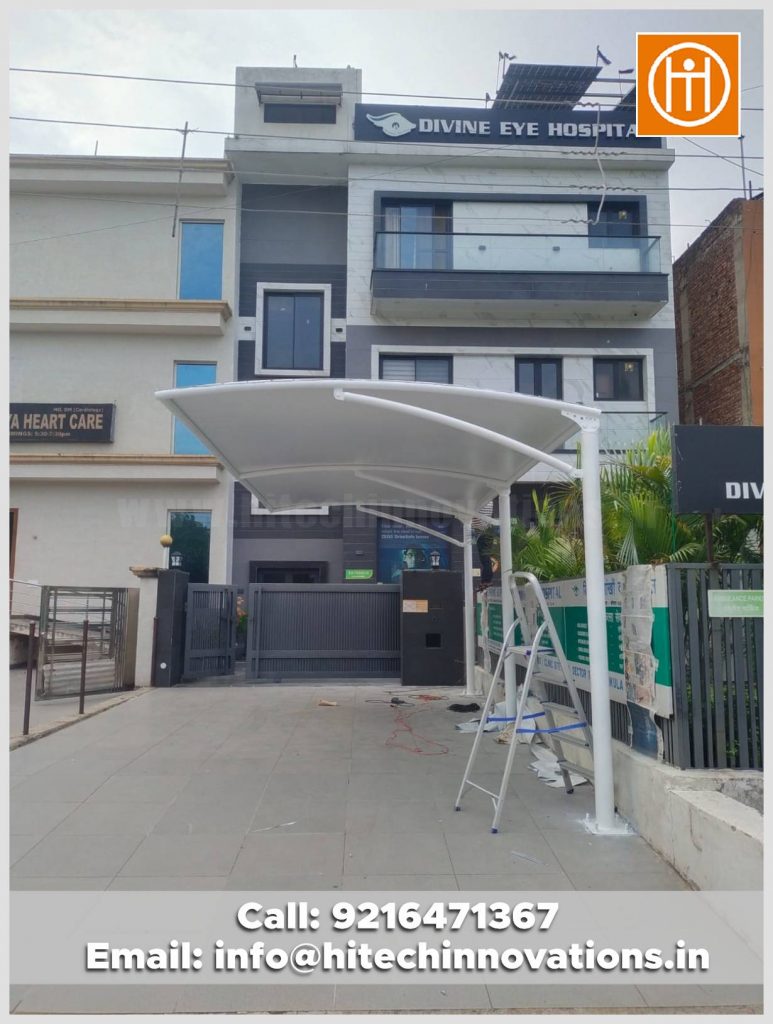 Wide view of a professional tensile car parking shelter in front of Divine Eye Hospital, manufactured by ISO 9001:2015 certified Hitech Innovations.