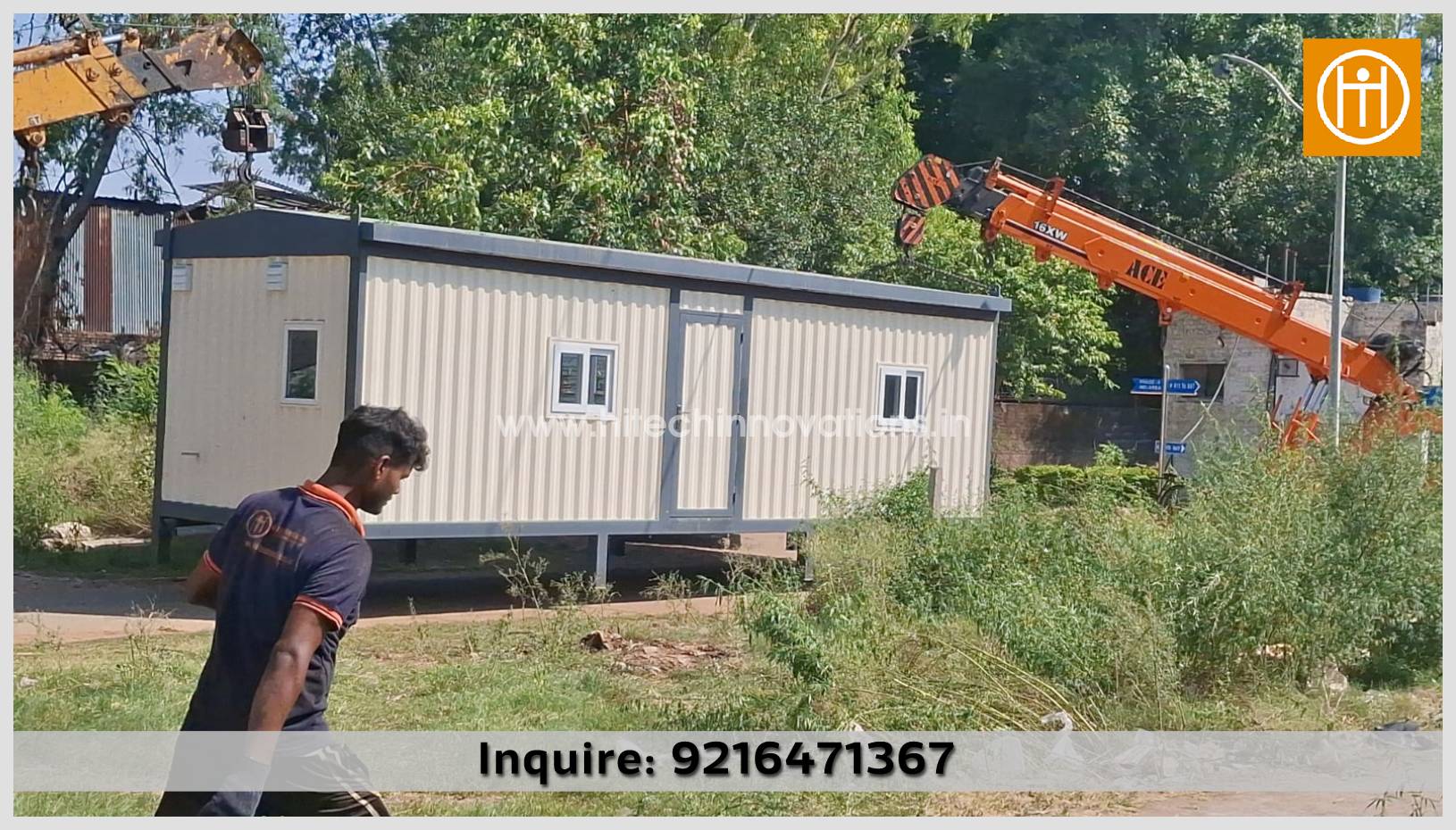 A team member of Hitech Innovations, India's leading manufacturer of container homes, navigates near a versatile office-cum-residential container equipped with two rooms, a pantry, and a toilet, as it is being installed by a crane.