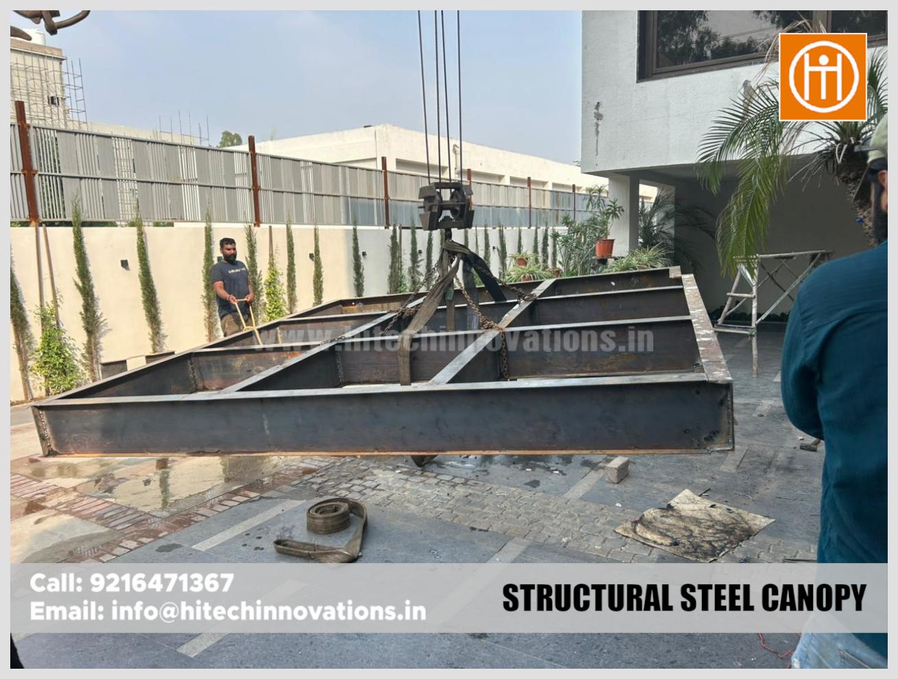 Construction crew positioning a heavy steel structure with crane assistance.