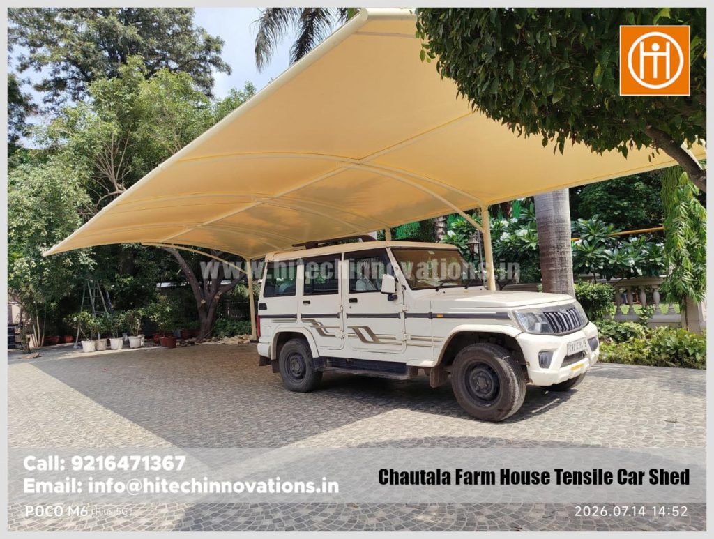 Multiple vehicles parked under a large, durable tensile parking shade.