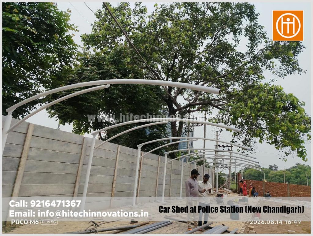 Workers reviewing the site layout during the early construction phase of the tensile car parking shed in New Chandigarh.