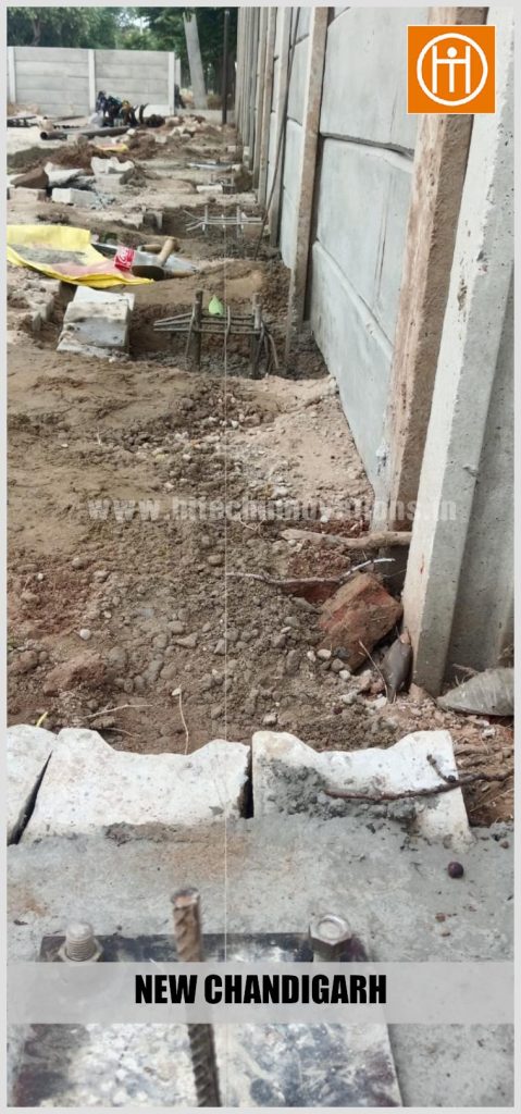 Perspective shot highlighting an installed base plate and anchor bolts in the foreground with rebar cages lined up in the background.