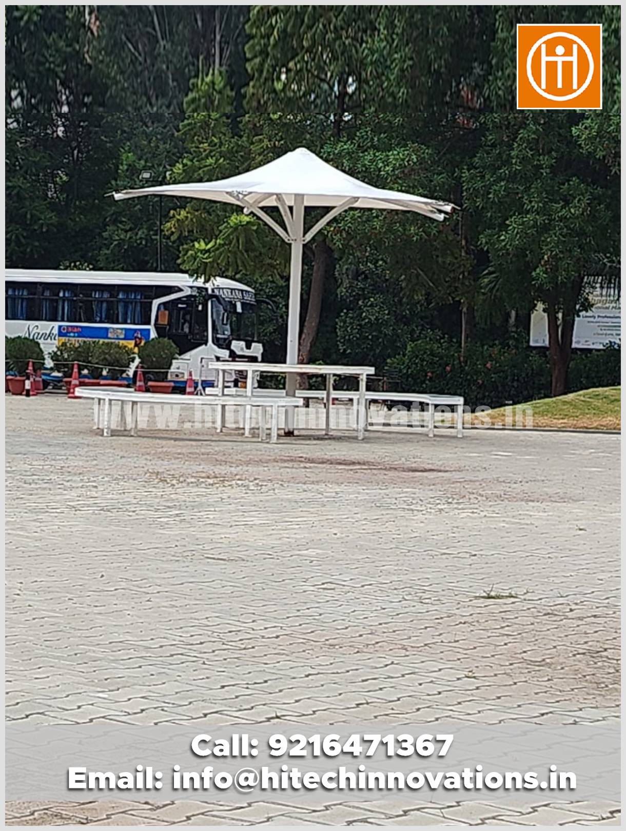 Tensile conical umbrella installed outdoors at Lovely Professional University, featuring attached seating and tables for students.