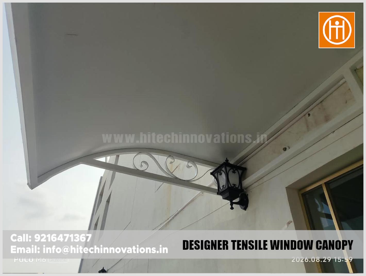 Underneath view highlighting the smooth finish and structural design of the installed tensile window canopy