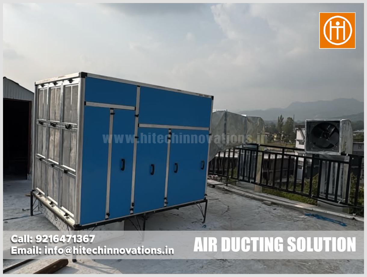Industrial blue and silver air handling unit installed on a building rooftop with connected ventilation ductwork and company branding by Hi-Tech Innovations