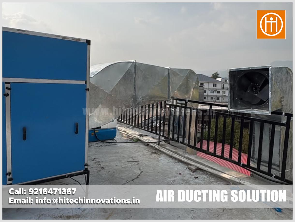 Rooftop view of commercial galvanized steel air ducting connected to an industrial ventilation unit and exhaust fan with contact details overlay