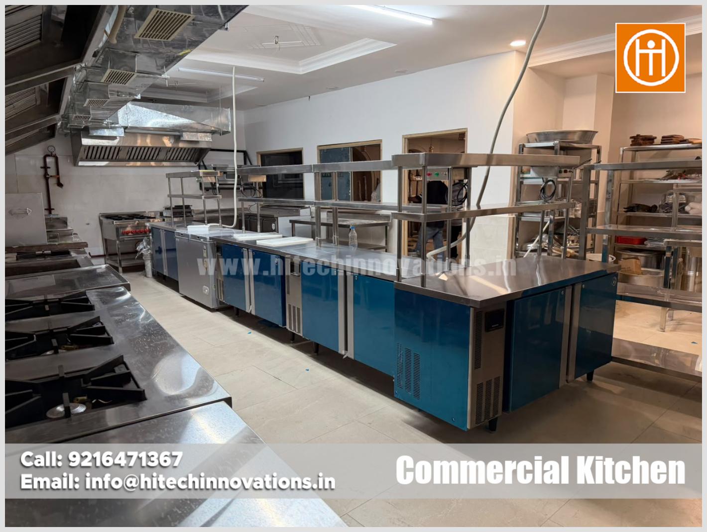 Custom blue-front undercounter refrigerators with stainless steel preparation counters and overhead pick-up shelves in commercial kitchen
